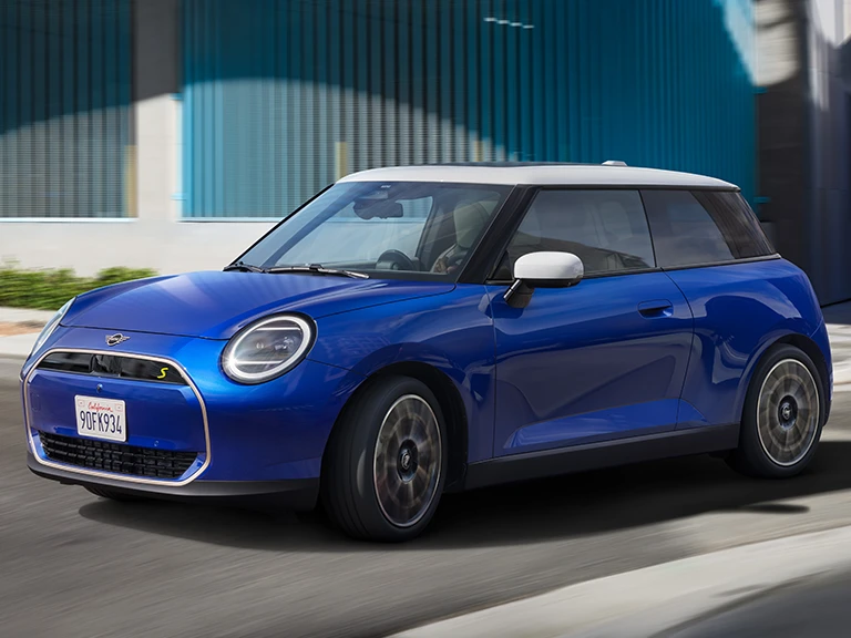 MINI Cooper in Blazing Blue Metallic driving on an urban street.