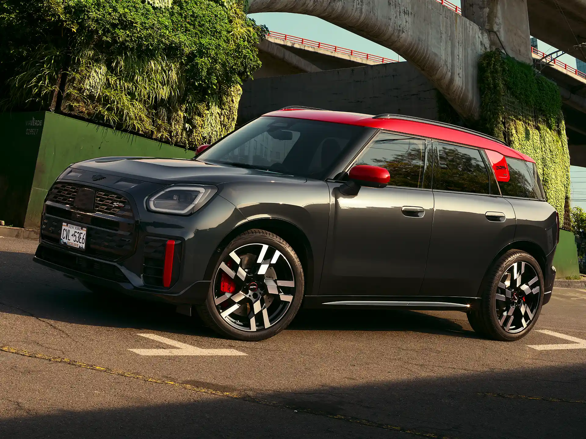MINI Countryman John Cooper Works in Midnight Black II with Chili Red roof parked on an urban street.